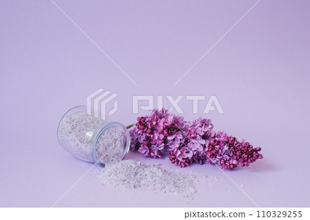 Bath salt and lilac flowers on the background. Cosmetics for spa treatments Bath salt and lilac flowers on the background. Cosmetics for spa treatments 110329255