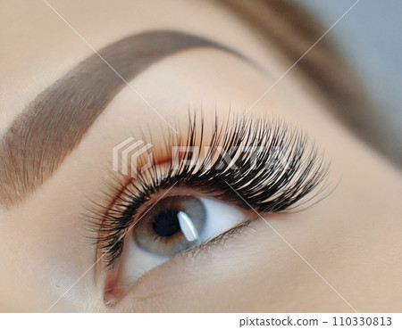 Eyelash extensions, close-up of young woman's eyes 110330813