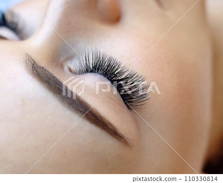 Eyelash extensions, close-up of young woman's eyes 110330814