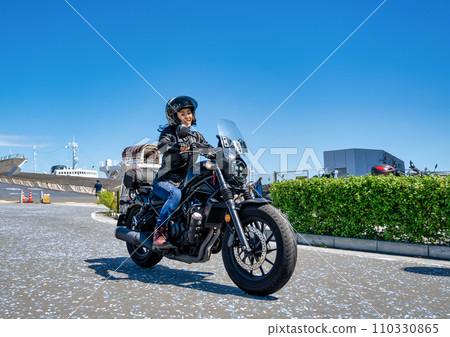 A female rider touring Yokohama on a cruiser bike 110330865