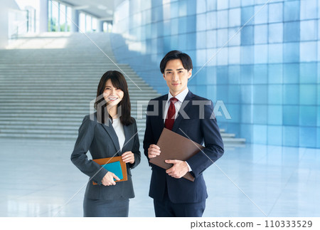 A businessman working in an office and a business woman 110333529