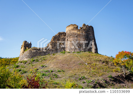 An old ruined fortress on the hill of the mountain 110333699
