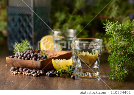 Gin with ingredients on an old wooden table. Gin with ingredients on an old wooden table. 110334401