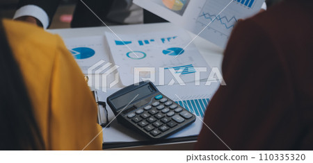 Financial analysts analyze business financial reports on a digital tablet planning investment project during a discussion at a meeting of corporate showing the results of their successful teamwork. 110335320