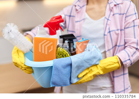 Woman in rubber protective yellow gloves holding cleaning tools. house chores. Woman in rubber protective yellow gloves holding cleaning tools. house chores. 110335784