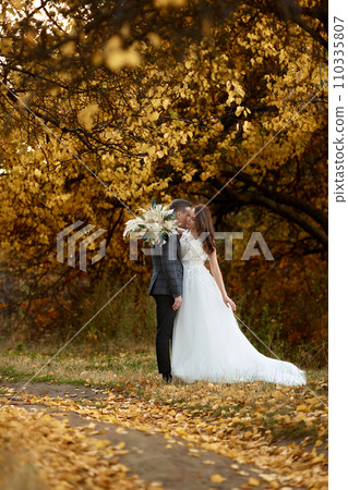 beautiful sensual bride in white wedding dress and groom standing outdoor on natural background 110335807