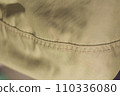 protective work clothes in beige and brown colors. Factory stitches on thick fabric. Close-up texture 110336080