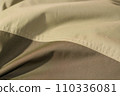 protective work clothes in beige and brown colors. Factory stitches on thick fabric. Close-up texture 110336081