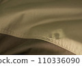 protective work clothes in beige and brown colors. Factory stitches on thick fabric. Close-up texture 110336090