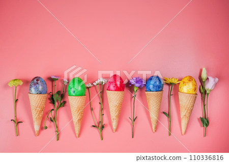 Colourful eggs in waffle cones on a pink background. Flat lay Colourful eggs in waffle cones on a pink background. Flat lay 110336816