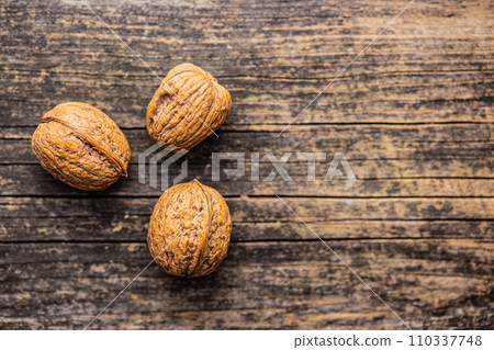 Three walnuts on wooden table. Top view. 110337748