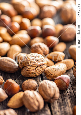 A mix of different nuts on wooden table. 110337754