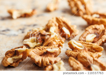 Peeled dried walnut kernels on kitchen table. Peeled dried walnut kernels on kitchen table. 110337763
