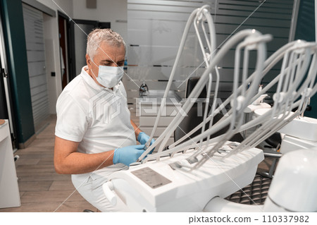 An attentive dentist, ready to receive the patient, maintains a trusting atmosphere in his office, where special attention is paid to every aspect of dental treatment. An attentive dentist, ready to receive the patient, maintains a trusting atmosphere in his office, where special attention is paid to every aspect of dental treatment. 110337982