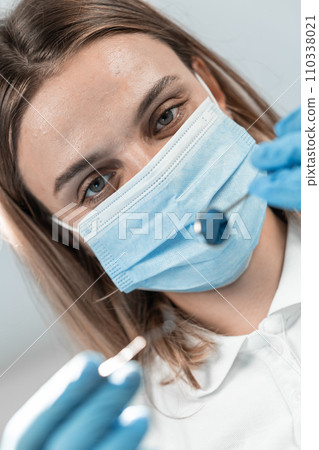 A professional dentist in her dental office is image of real expert who combines warmth and confidence. With attention to detail and a smile, she guides her patients through every stage of treatment. A professional dentist in her dental office is image of real expert who combines warmth and confidence. With attention to detail and a smile, she guides her patients through every stage of treatment. 110338021