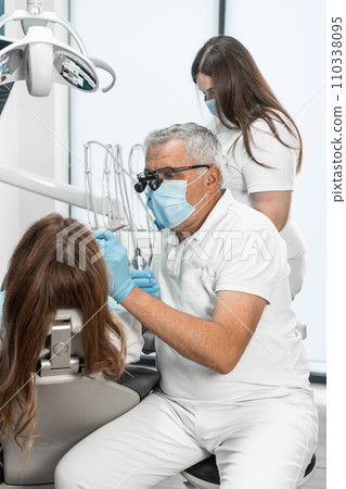 The dentist works in a modern and bright clinic, creating a pleasant environment for treatment. Cleanliness and order are its basic principles. 110338095