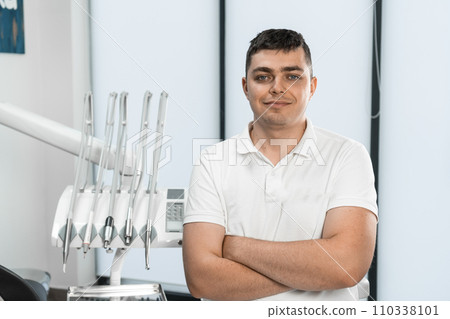With care and dedication to his craft, a male dentist works in his own dental office, ready for any dental procedure. With care and dedication to his craft, a male dentist works in his own dental office, ready for any dental procedure. 110338101