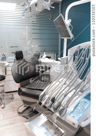 An empty dental office in which the patient's chair, prepared for the appointment, demonstrates a seamless and professional approach to service. 110338103