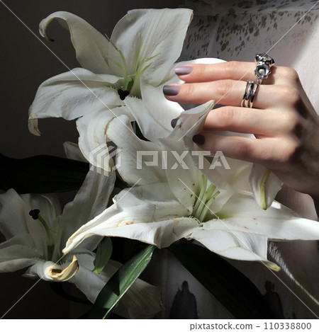 Female hand with silver rings holds a bouquet of flowers Female hand with silver rings holds a bouquet of flowers 110338800