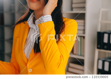 Young smiling business woman using smartphone near computer in office, copy space 110339005