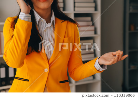Young smiling business woman using smartphone near computer in office, copy space 110339006