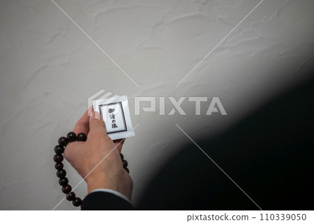 A man's hand holding rosary beads and purifying salt A man's hand holding rosary beads and purifying salt 110339050