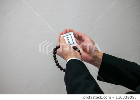 A man's hand holding rosary beads and purifying salt A man's hand holding rosary beads and purifying salt 110339053