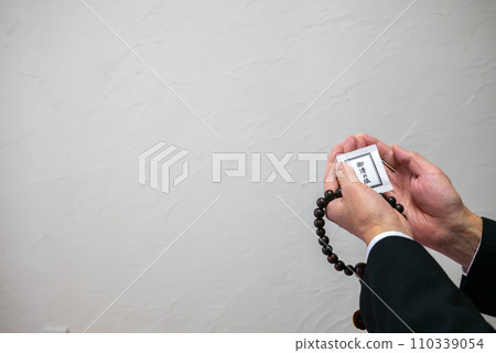 A man's hand holding rosary beads and purifying salt A man's hand holding rosary beads and purifying salt 110339054