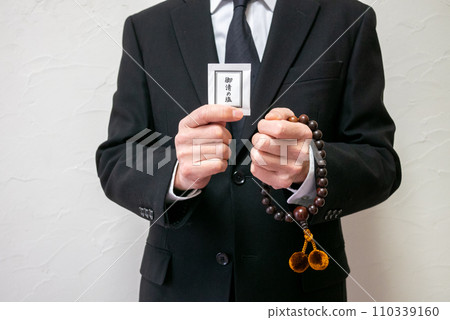 A man with rosary beads and purifying salt 110339160