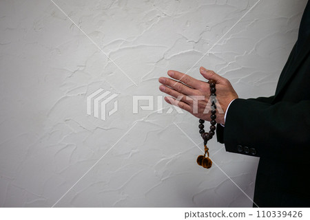 Hand of a man holding rosary beads 110339426