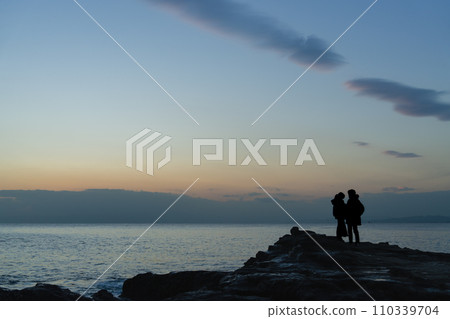 Two people standing at dusk Two people standing at dusk 110339704