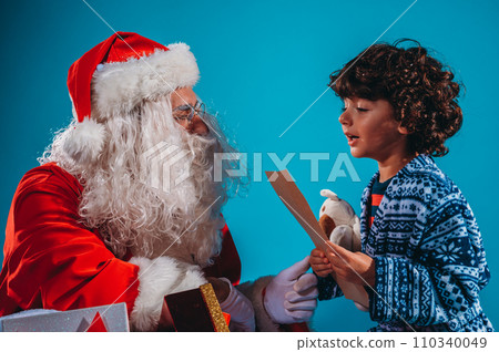Santa Claus listens the gifts request of a child for Christmas 110340049