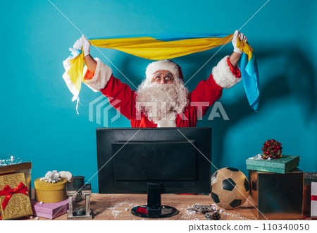 Joyful Santa Claus, soccer fan, watches a game on television 110340050
