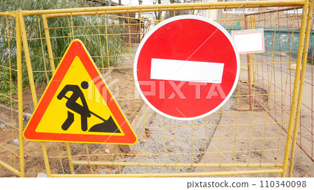 Stop and road works signs on a fence, construction and building industry. Stop and road works signs on a fence, construction and building industry. 110340098