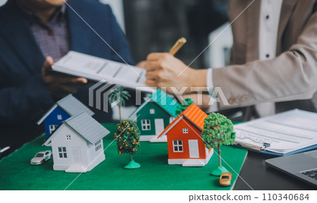 Real estate brokerage agent Deliver a sample of a model house to the customer, mortgage loan agreement Making lease and buy and sell house And contract home insurance mortgage loan concept 110340684