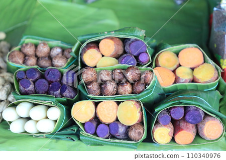 Group of waternut, chinese water chestnut, purple and yeloow sweet potato in banana leaf plate in the fresh market. Group of waternut, chinese water chestnut, purple and yeloow sweet potato in banana leaf plate in the fresh market. 110340976