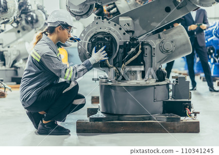 Engineer robotic mechanic women technician working in advance robotic industry plant work assembly robot arm repair fix maintenance or service large machine by hand skill 110341245