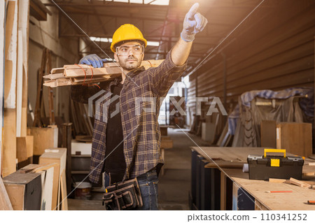 portrait smart builder wood male furniture maker, sawmill worker professional standing strong and confident carrying wooden planks 110341252