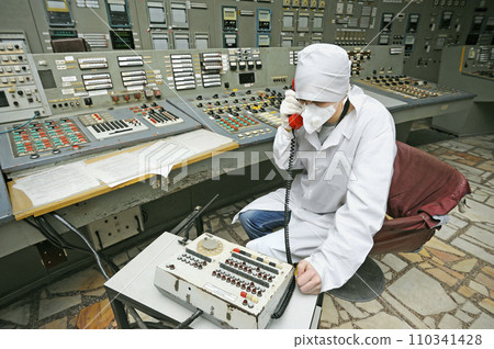 Operator holding a receiver calling on the phone. Control operations room of the Chornobyl Nuclear Power Plant 110341428