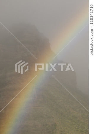 Rainbow and Tirajana cliffs in the fog. Rainbow and Tirajana cliffs in the fog. 110341716