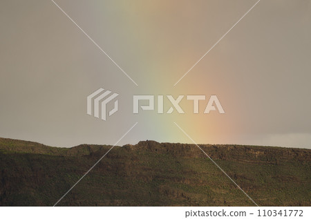 Rainbow over a ridge of the Tirajana crater. 110341772