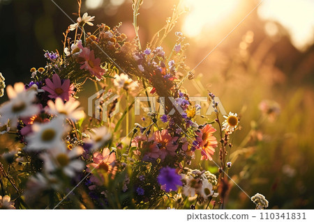 Wild flowers wreath in morning meadow in sunrise Wild flowers wreath in morning meadow in sunrise 110341831