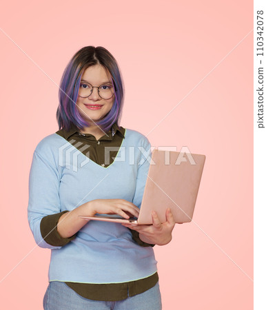 Friendly female student with laptop smiles against cheerful pink background. Dedicated and motivated student who excels in studies, creating vision of success and achievement in educational journey 110342078