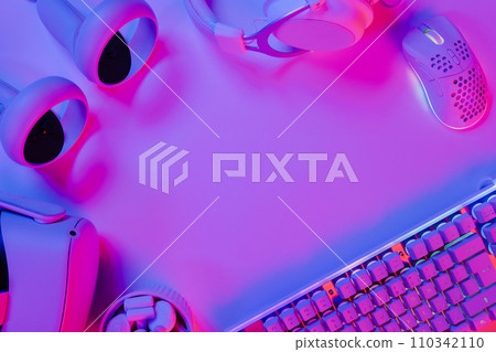 Illuminated keyboard and gaming gadgets on desk Illuminated keyboard and gaming gadgets on desk 110342110