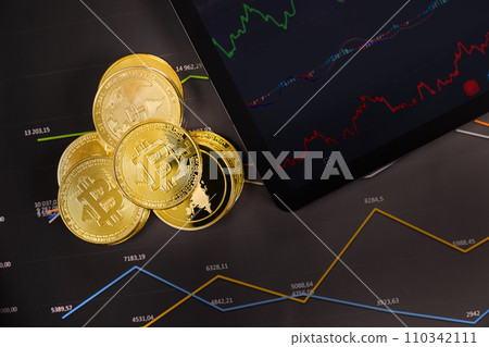 Crypto coins near digital tablet over graph Crypto coins near digital tablet over graph 110342111