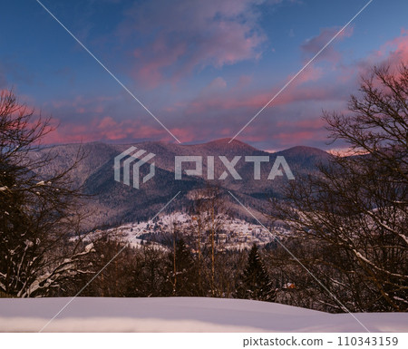 Winter sunset alpine hills with fir forest view from mountain village. Picturesque seasonal, nature and countryside beauty concept scene. Winter sunset alpine hills with fir forest view from mountain village. Picturesque seasonal, nature and countryside beauty concept scene. 110343159