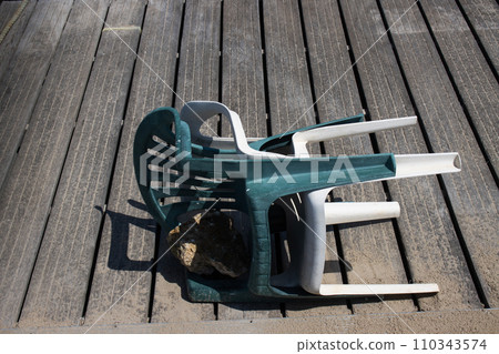 Two fallen plastic chairs 110343574