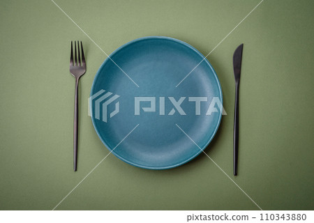 Empty round ceramic plate on a plain background, flatley with copy space 110343880