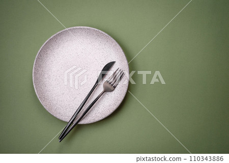 Empty round ceramic plate on a plain background, flatley with copy space 110343886