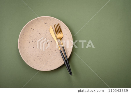 Empty round ceramic plate on a plain background, flatley with copy space 110343889